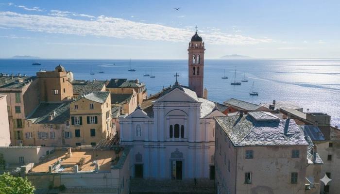 Cathédrale Sainte-Marie de Bastia surplombant la mer avec son clocher et ses bâtiments environnants.