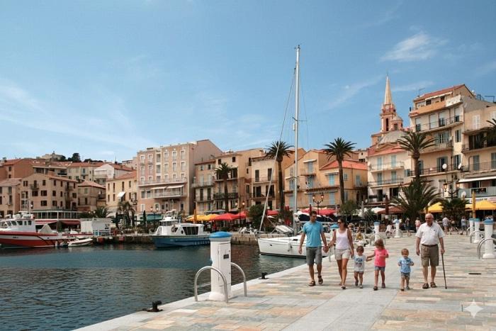 Promenade du quai Landry à Calvi avec terrasses, bateaux et façades colorées