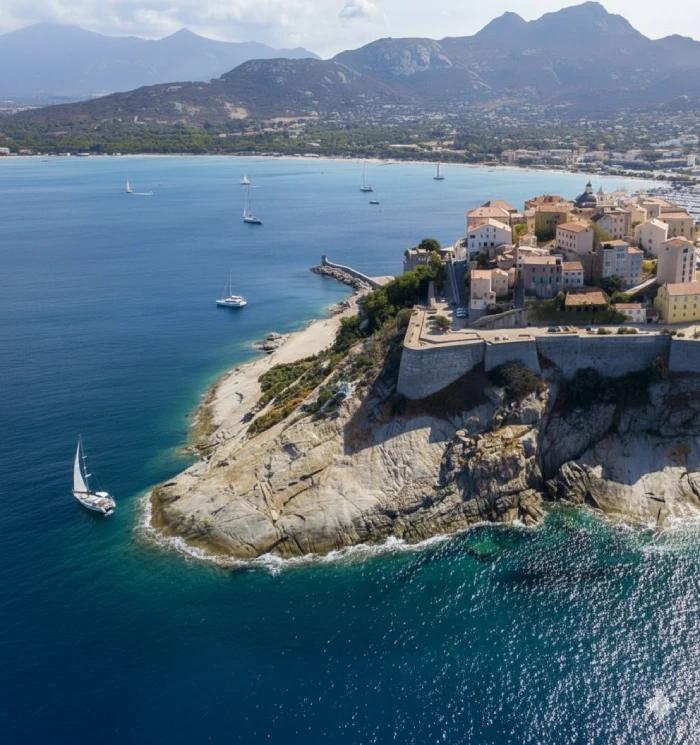 Les remparts de Calvi surplombant le port et la ville illuminée au crépuscule
