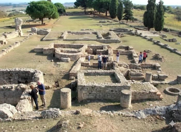 Vue du site archéologique d’Aléria avec ruines romaines et visiteurs parcourant les vestiges