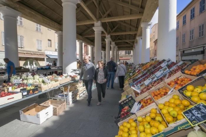 Vue du marché couvert de l’Île-Rousse avec ses étals de fruits et légumes et les producteurs locaux sous la halle historique.